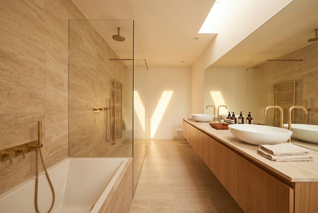 Spa-style master bathroom remodel with travertine walls and freestanding tub in Tarzana, CA